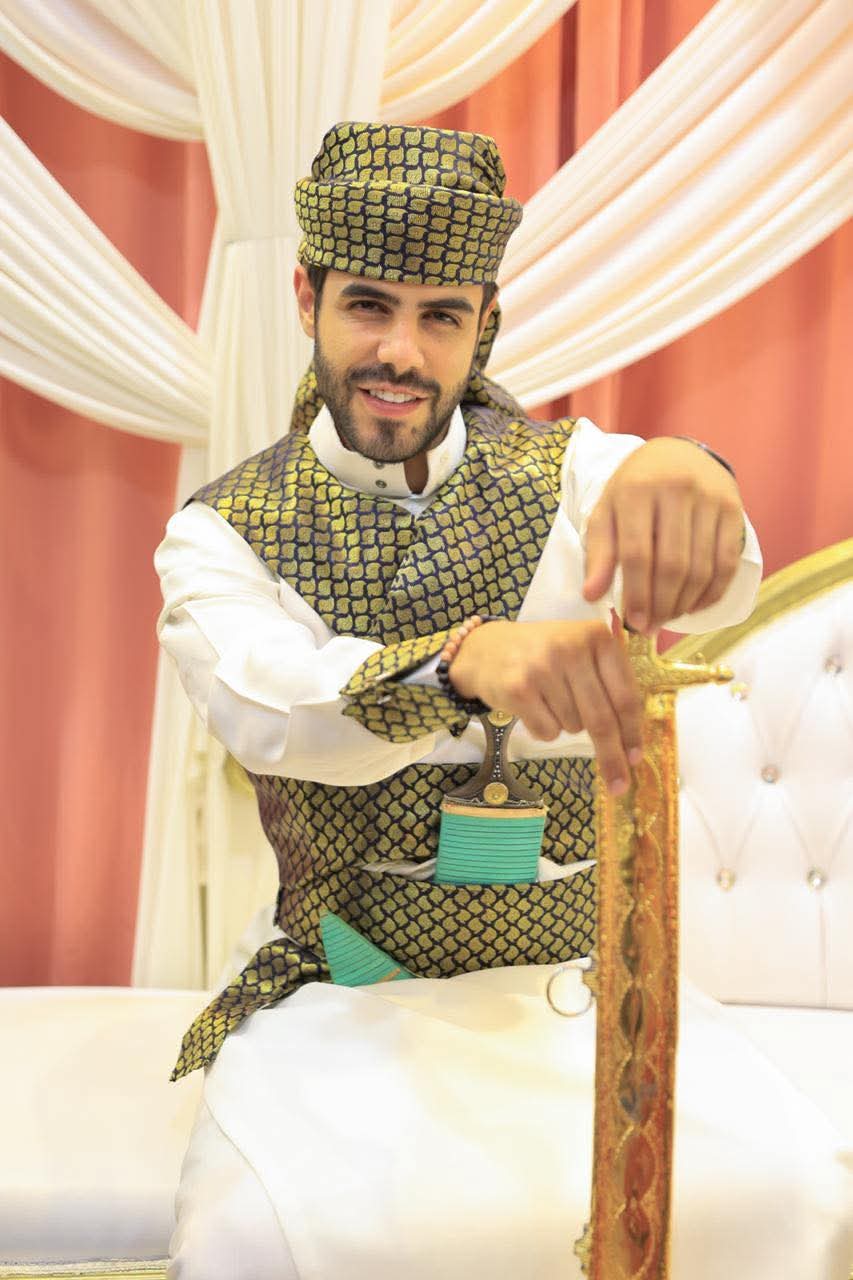 عريس بثوب أبيض وسيف ذهبي